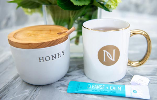 Lifestyle shot of NeoraFit Cleanse + Calm Nightly Gentle Cleanse Powder being used in several mugs.