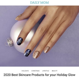 Image of a woman’s hand holiday-inspired nail polish holding a white shimmery tree ornament.